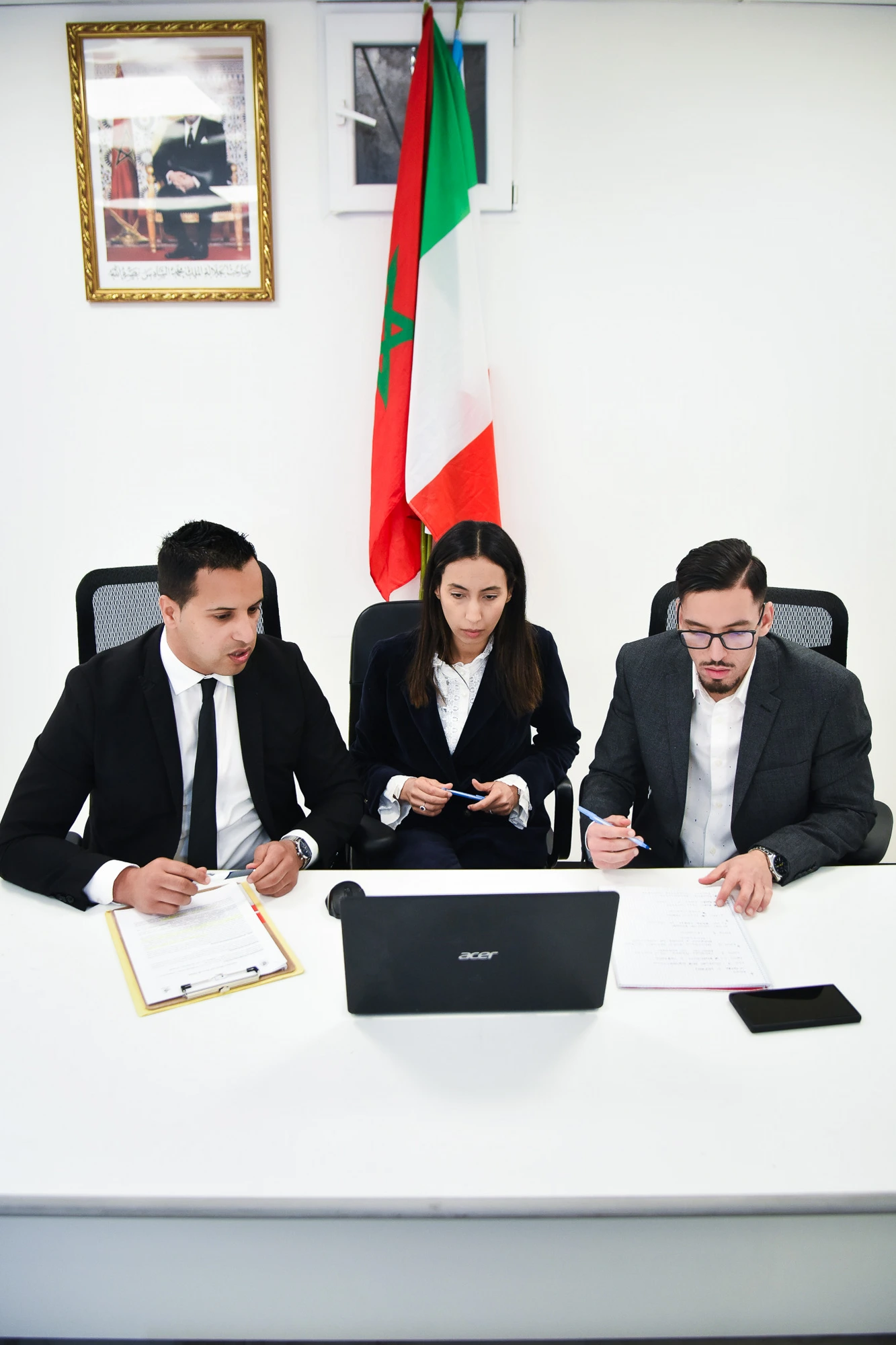 I tre soci di SWM Consulting — Mohammed Hammouch, Sana Ed Dami e Wissam El Aissaoui — al lavoro con le bandiere di Italia e Marocco